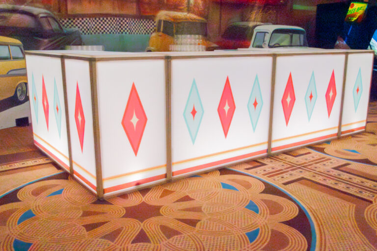 Illuminated white event bar with red and teal diamond pattern and retro diner styling