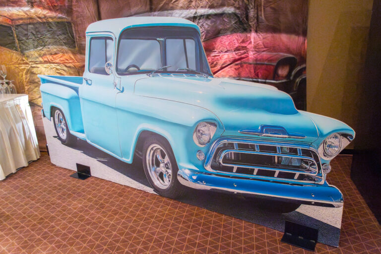Life-sized cutout of a light blue vintage pickup truck at a themed indoor event