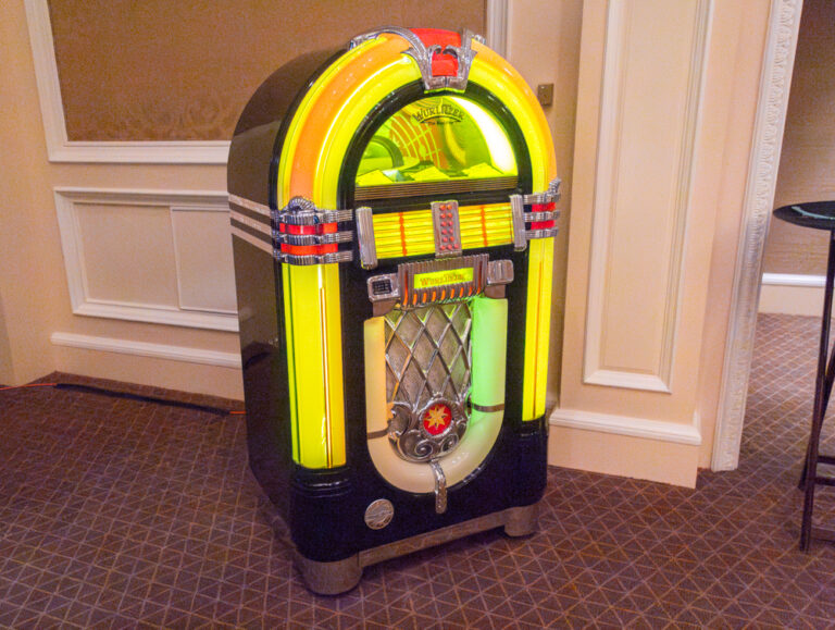 Vintage Wurlitzer jukebox lit in yellow and red at an indoor event