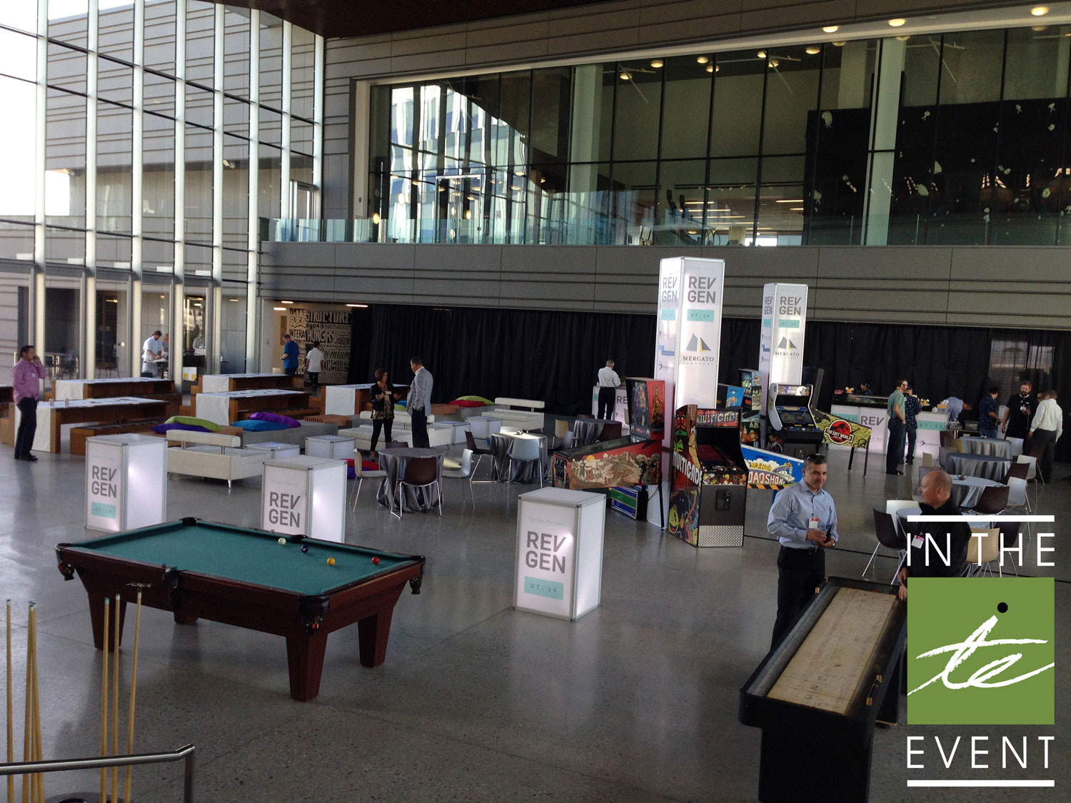 Corporate trade show setup with branded LED towers, pool table, arcade games, and lounge seating designed by In The Event.