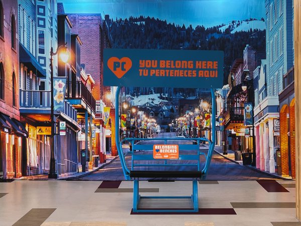 Blue ski lift chair with custom Park City branding in front of a Park City Main Street Backdrop at Park City High School.