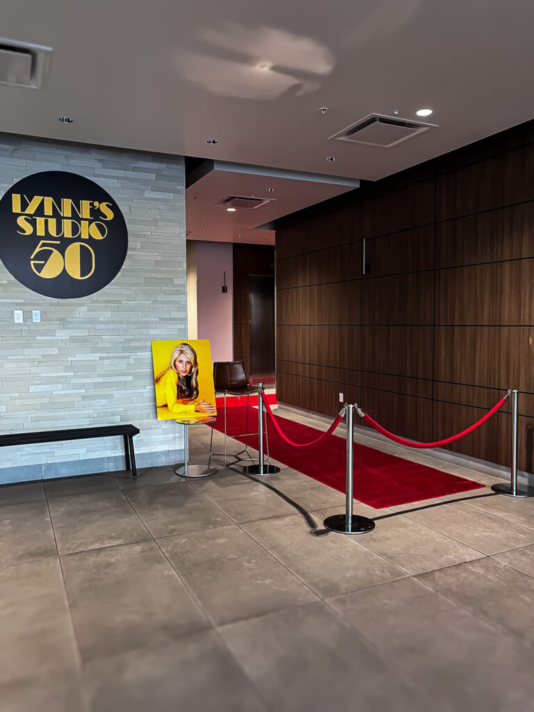 Red carpet entrance with custom “Lynne’s Studio 50” signage and a portrait on display.