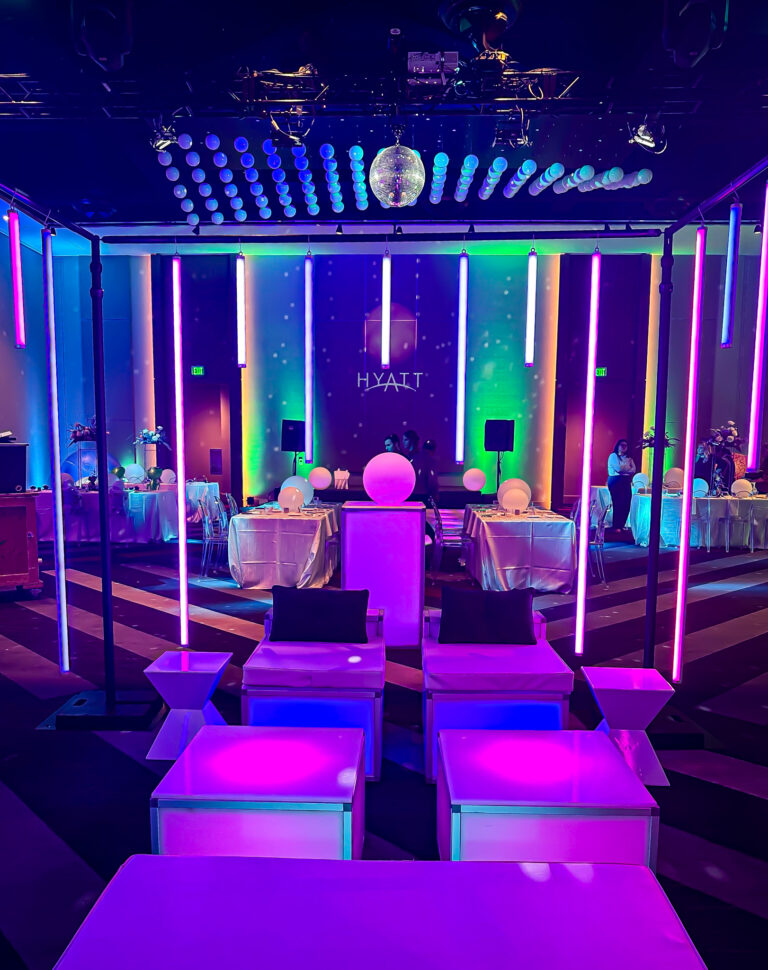 LED event lounge with glowing modular furniture, vertical light tubes, and space-themed decor for rent.