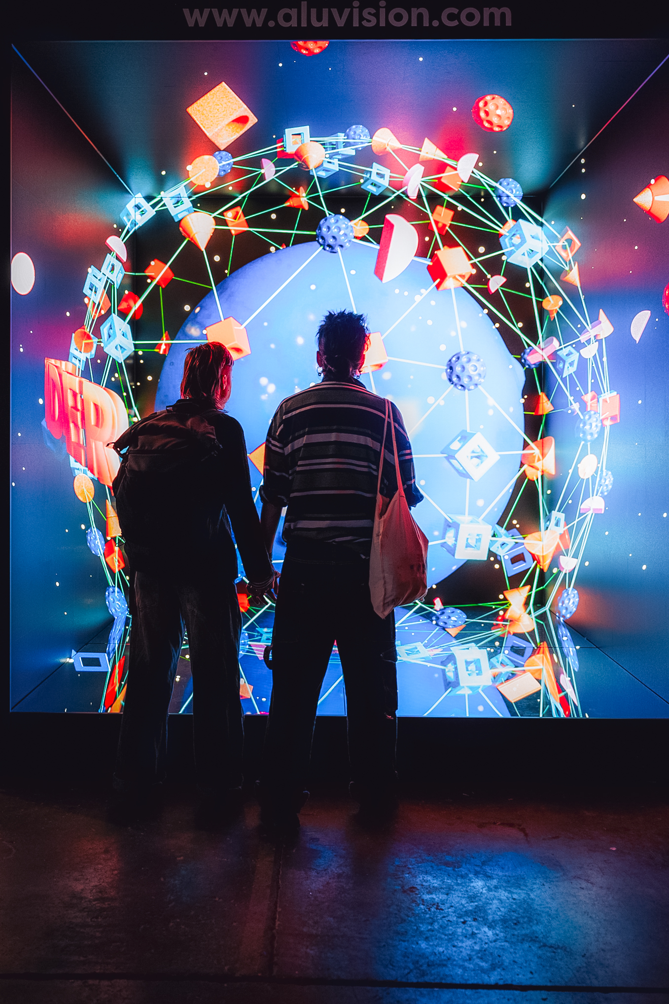 People observing an LED screen displaying a custom digital graphic at a corporate event.