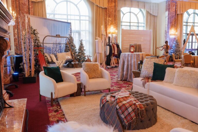Winter-themed lounge with soft seating, plaid accents, photo booth, and violinist at the Salt Lake City NACE Launch Event 2024