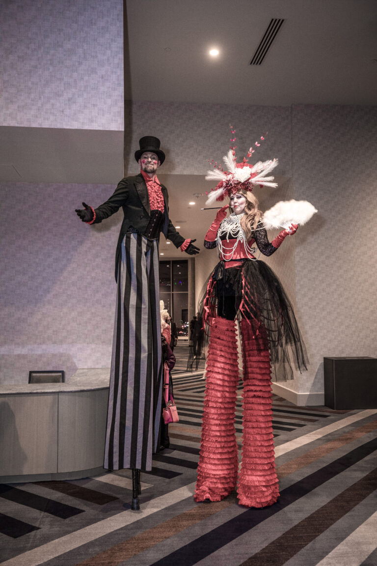 Two themed stilt performers in red and black costumes pose at the SILAC Insurance Gala 2024