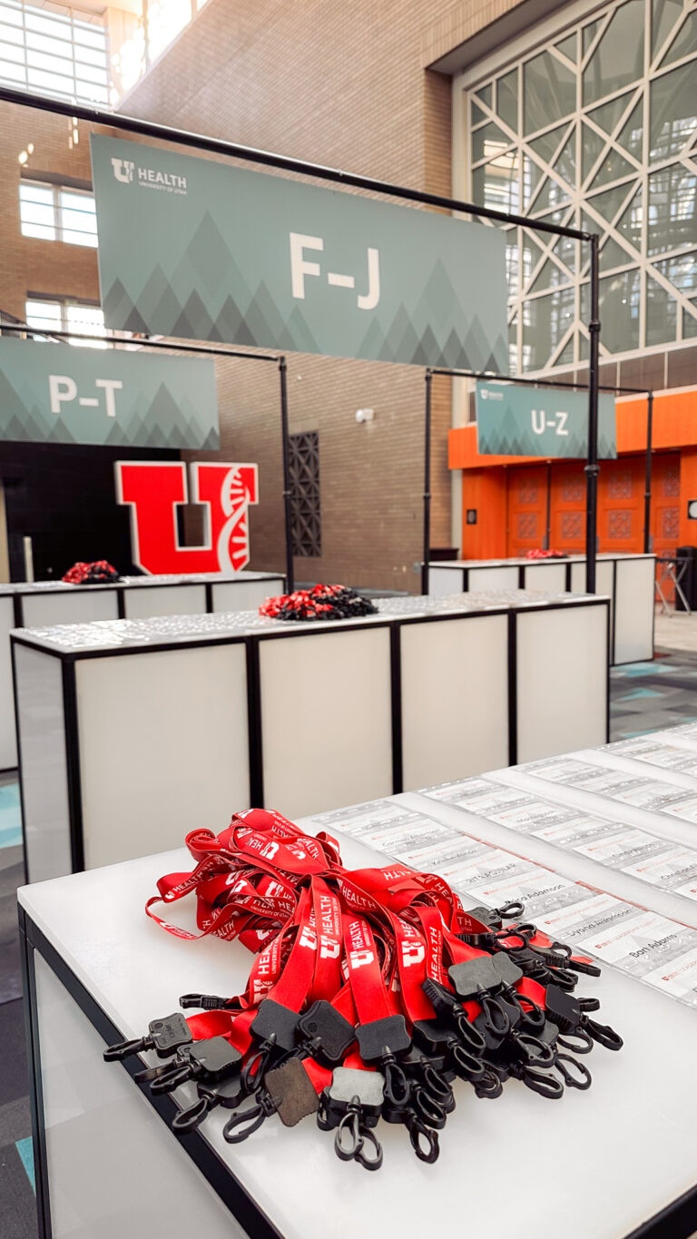 Sleek event lounge furniture with white modular seating, silver decorative pillows, a clear table, and blue LED furniture rentals lighting.