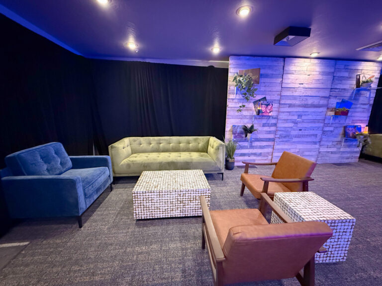 modern lounge setup with velvet and leather seating at Vizio Lounge during Sundance event, featuring accent lighting and wood panel backdrop