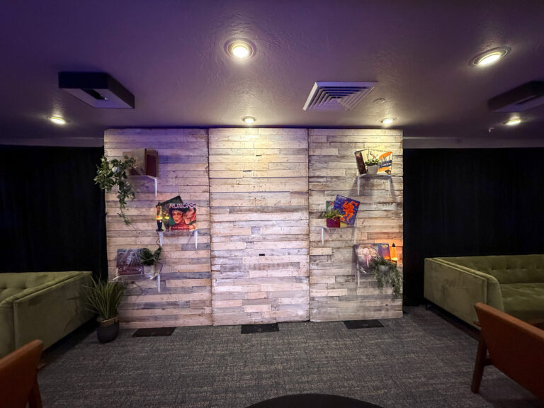 custom wooden wall display with album art and greenery decor at Vizio Lounge during Sundance event