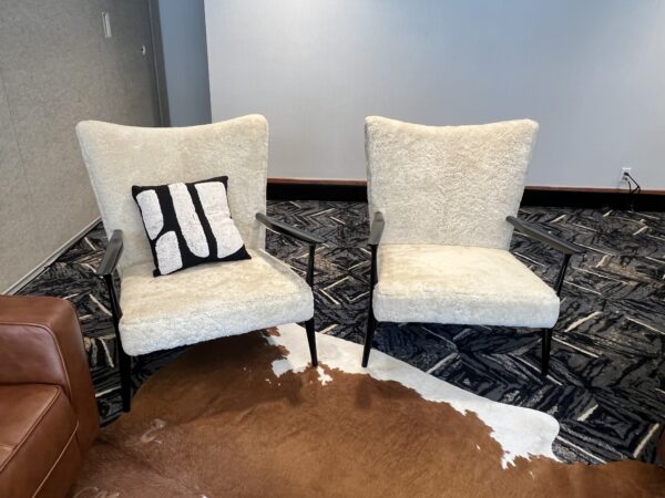 Two Marion Arm Chairs with cream textured upholstery and black metal frames styled as modern lounge seating for events