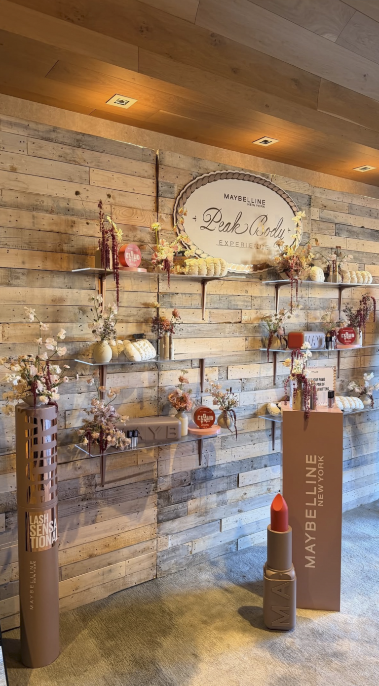 Custom branded display wall with whitewash pallet wall and floral styling for Maybelline New York Peak Body Experience at Blue Sky Lodge in Utah by In The Event