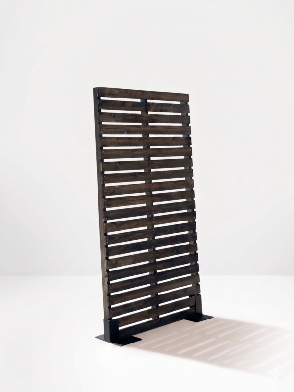 Side angle view of freestanding dark stained wood pallet wall panel on black metal base casting a shadow for rustic themed event decor rentals and corporate event production in Salt Lake City Utah