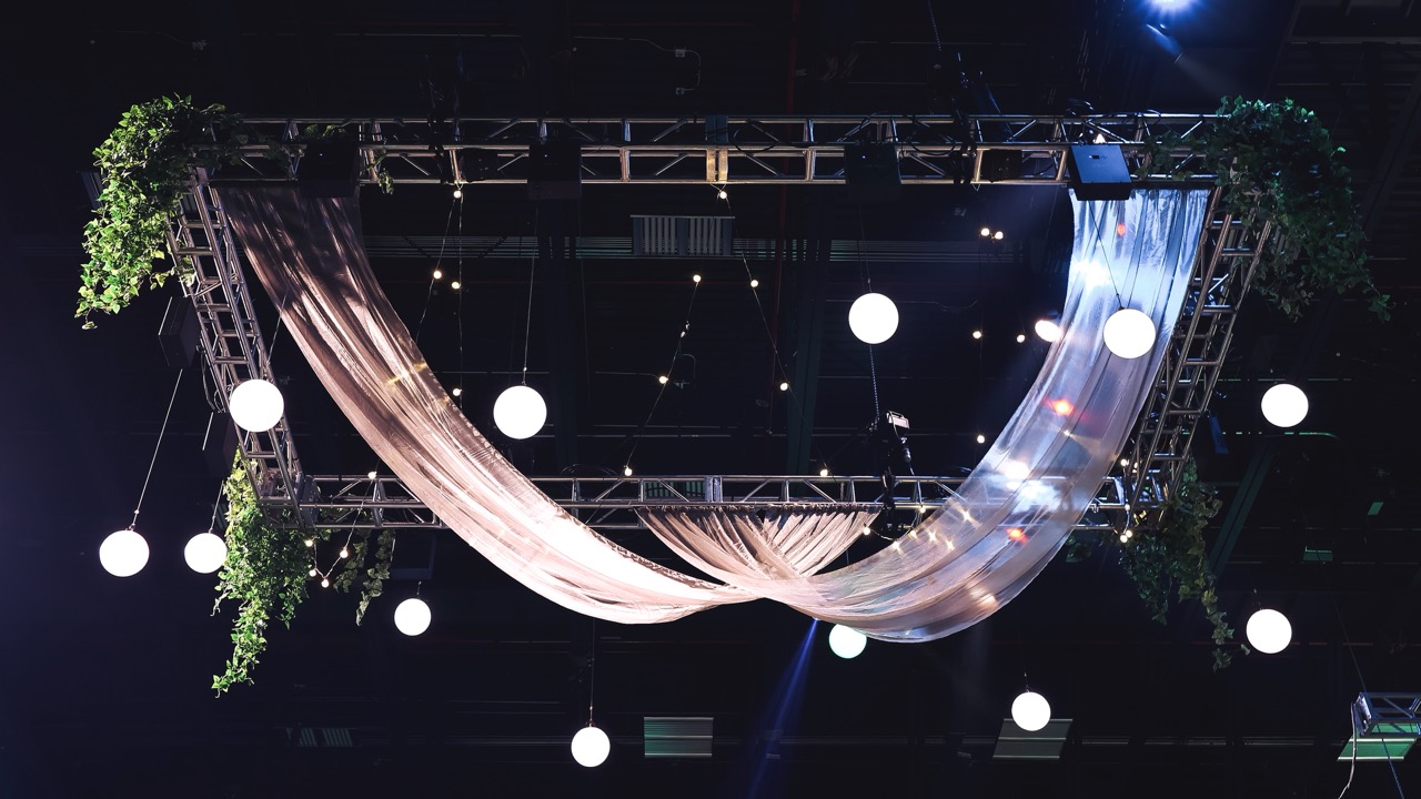 Ceiling drape installation with truss rigging and pendant lighting at UVU Ball produced by In The Event Utah