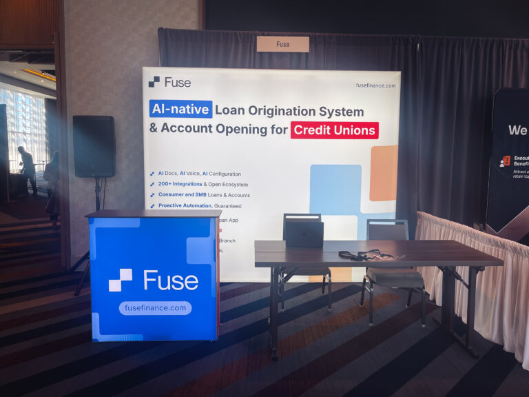 Custom trade show booth featuring a branded backwall display, illuminated counter, and exhibitor meeting space at the Utah Credit Union Association Summit.