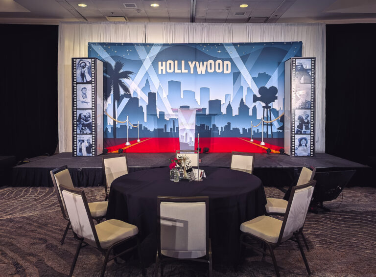 Hollywood-themed event stage with custom backdrop, red carpet, film reel décor, and podium at the Boys & Girls Great Futures Event at Marriott City Creek Downtown.