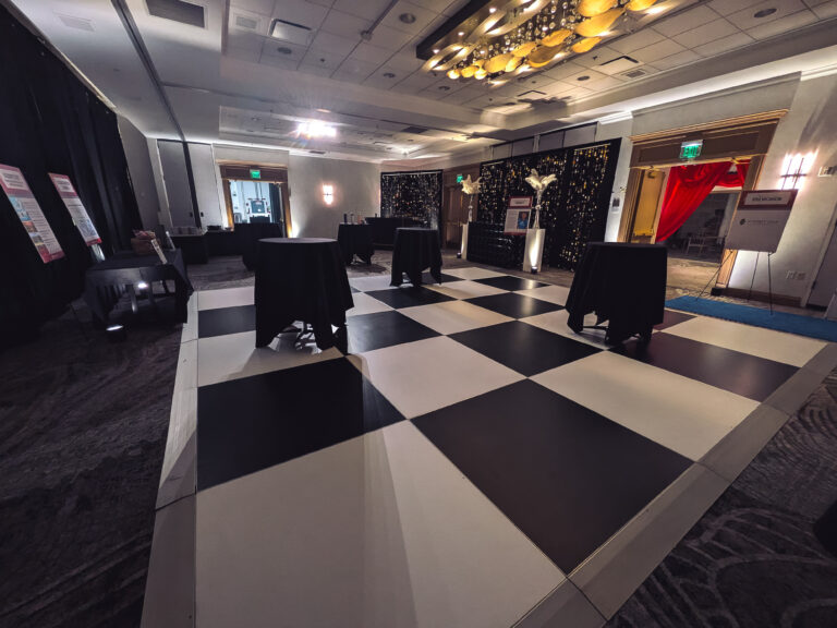 Hollywood-themed gala reception space featuring a black-and-white dance floor, cocktail tables, custom event bar, and elegant décor at the Great Futures Gala.