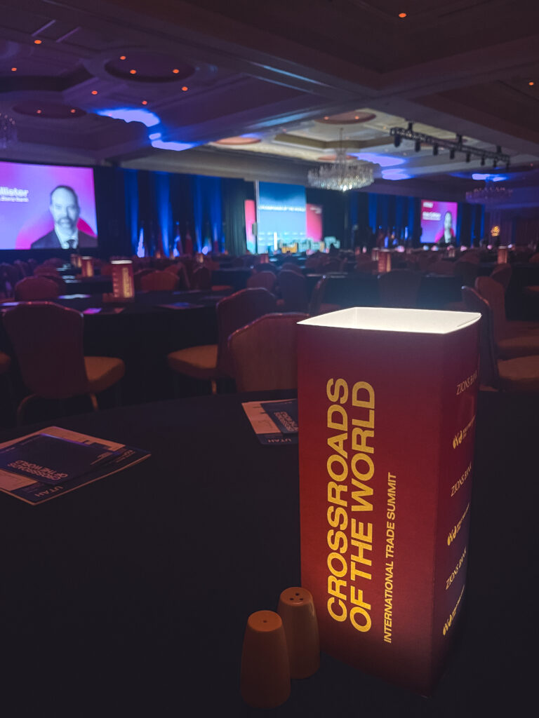Branded illuminated table centerpiece displayed in a conference ballroom during the Crossroads of the World International Trade Summit at The Grand America Hotel.