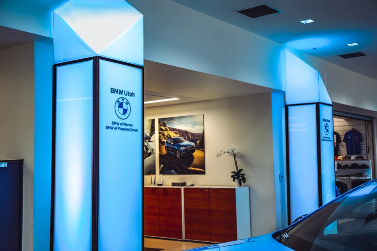 Custom illuminated BMW-branded columns with integrated LED lighting inside BMW of Murray showroom.