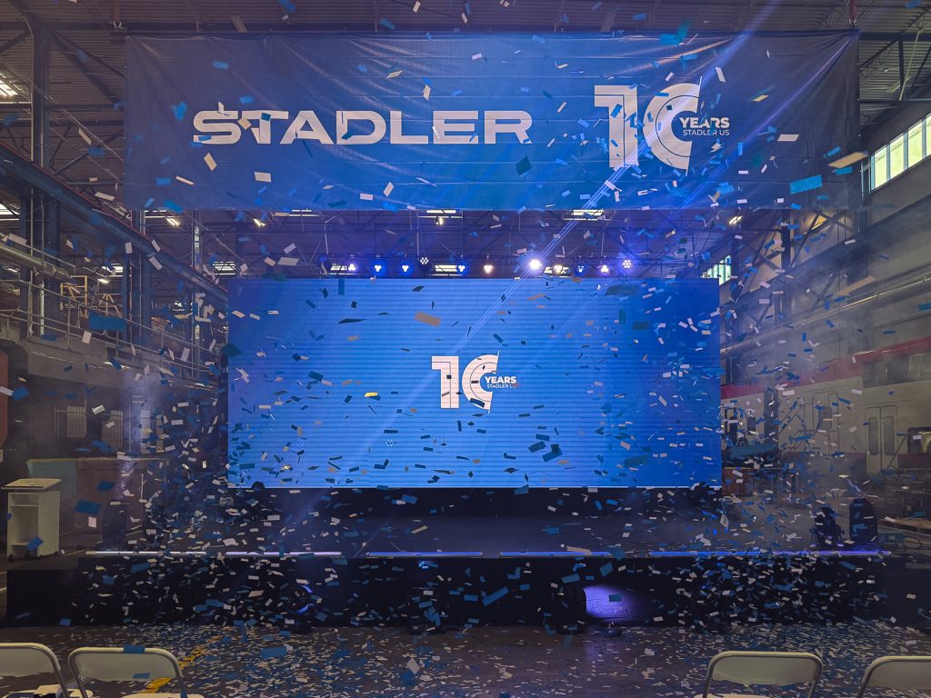 Large LED stage backdrop with confetti cannons celebrating Stadler US's 10-year anniversary.