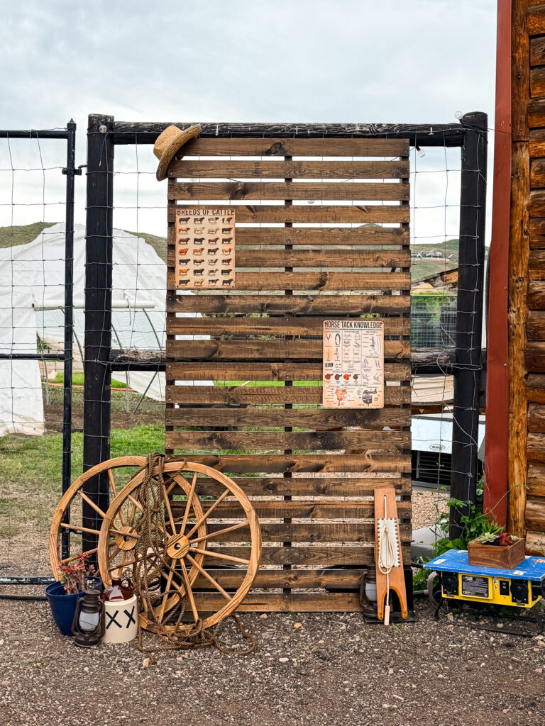 Rustic Western display featuring a reclaimed wood backdrop, wagon wheel, rope, lantern, and ranch-inspired decor at The Lodge at Blue Sky.