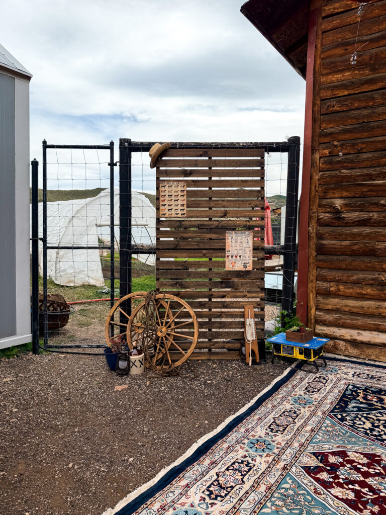 Rustic Western backdrop featuring a wood slat wall, wagon wheels, ranch decor, and vintage accessories at The Lodge at Blue Sky.