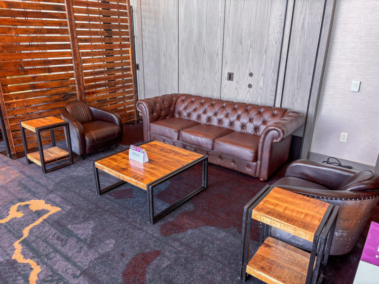 Industrial lounge furniture featuring a brown tufted Alpine sofa, matching Aviator chairs, woodland tables available from In The Event.