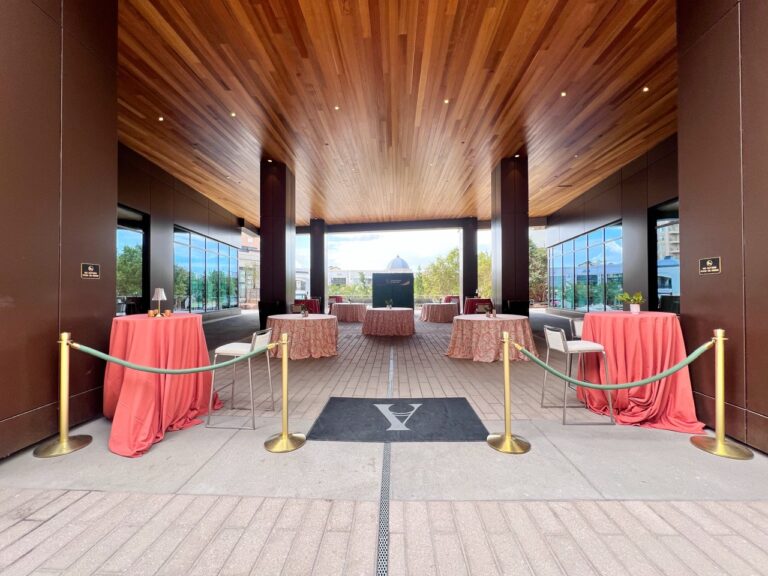 Covered outdoor event terrace at Asher Adams Salt Lake City featuring cocktail tables with coral and patterned linens, lounge seating, and elegant event décor by In The Event.