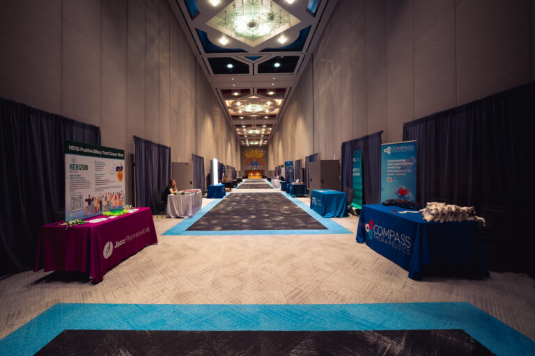 Wide view of the sponsor and exhibitor hallway at the CCF 2026 Annual Conference at the Salt Palace Convention Center, featuring branded exhibitor booths, sponsor displays, and directional carpet accents.