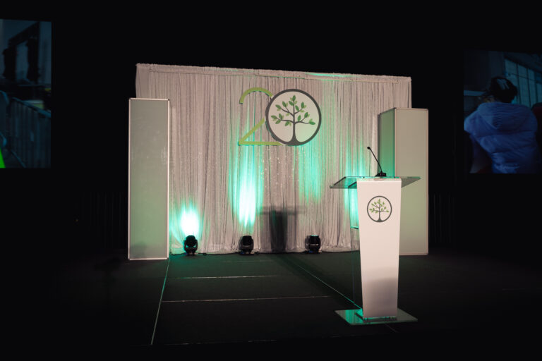 Close-up of the keynote stage at the CCF 2026 Annual Conference at the Salt Palace Convention Center, featuring a custom branded backdrop, illuminated podium, and professional stage lighting.