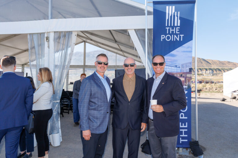 Attendees posing for a photo outside a grand opening event tent at The Point development in Draper, Utah in front of our 10ft Banner stands with custom prints.