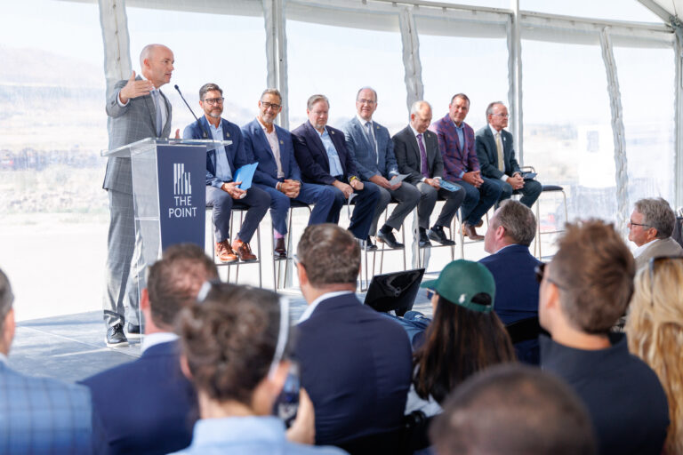 Governor Cox addressing attendees during the grand opening ceremony for The Point development in Draper, Utah with community and business leaders on stage. He stands in front of a custom branded podium from In The Event.