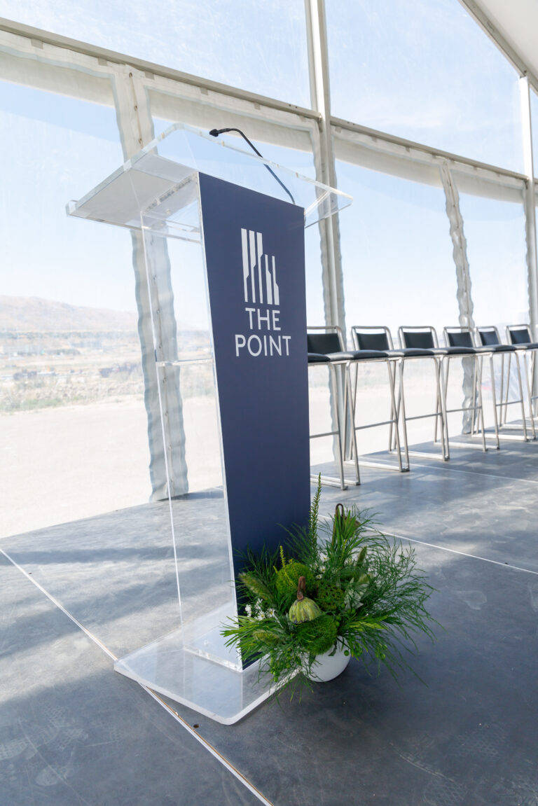 Clear acrylic podium with The Point branding on a presentation stage prepared for a grand opening ceremony in Draper, Utah.