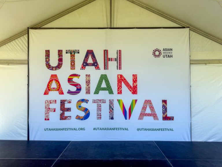 Large custom stage backdrop displaying the Utah Asian Festival branding inside an event tent, produced and installed by In The Event.