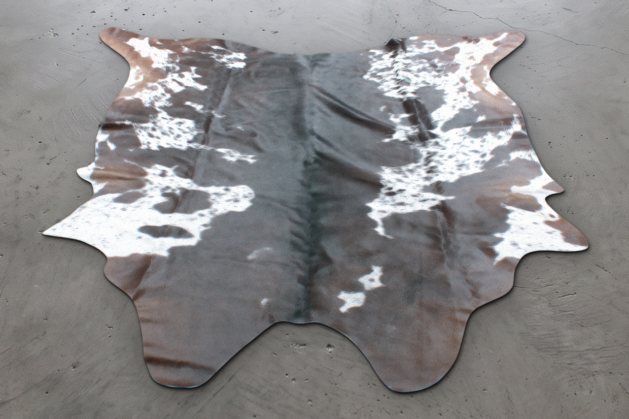 Dark brown cowhide rug with white speckled patches, approximately 7 feet, shown on a concrete floor